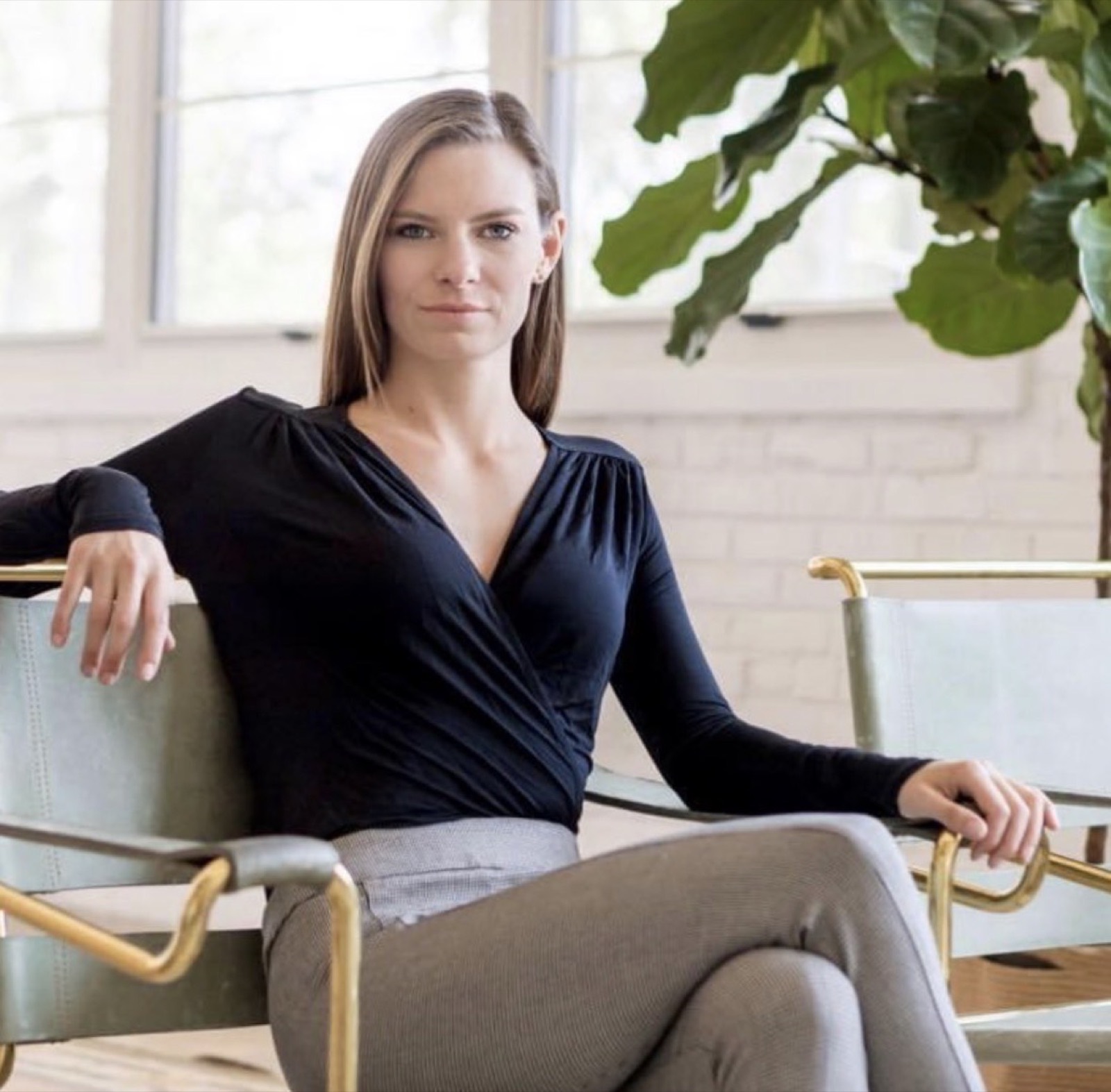 Kate Vollmer seated in a bright, plant-filled room